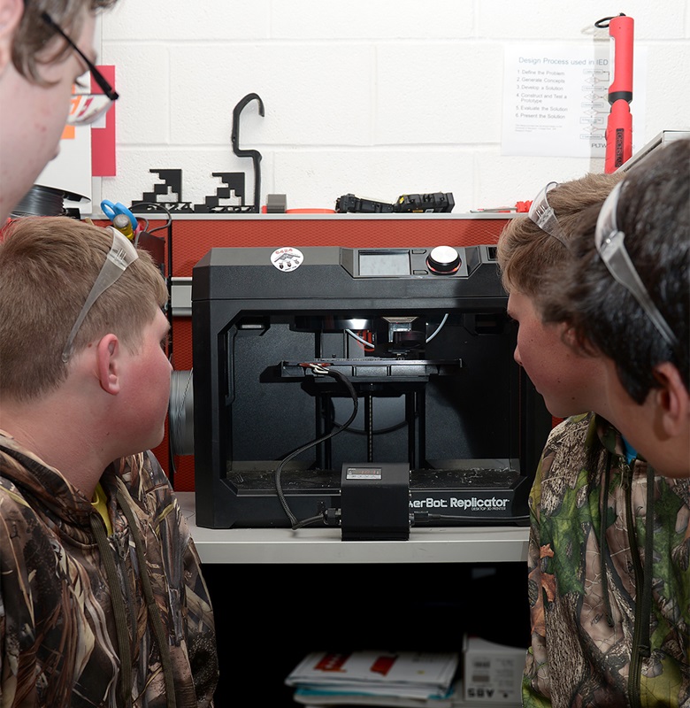 Stealth Panther Robotics students 3-D printing the part. Source: US Air Force.