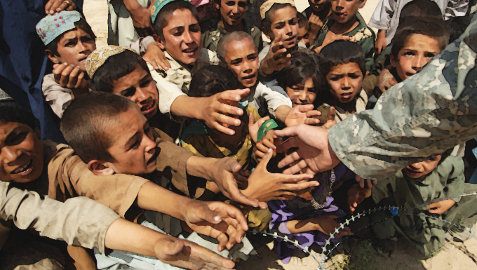 Refugee hands reaching out to service member