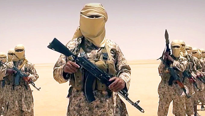 Image of foreign soldier with a full beige headscarf standing amongst other similar soldiers, holding a semi-automatic weapon.