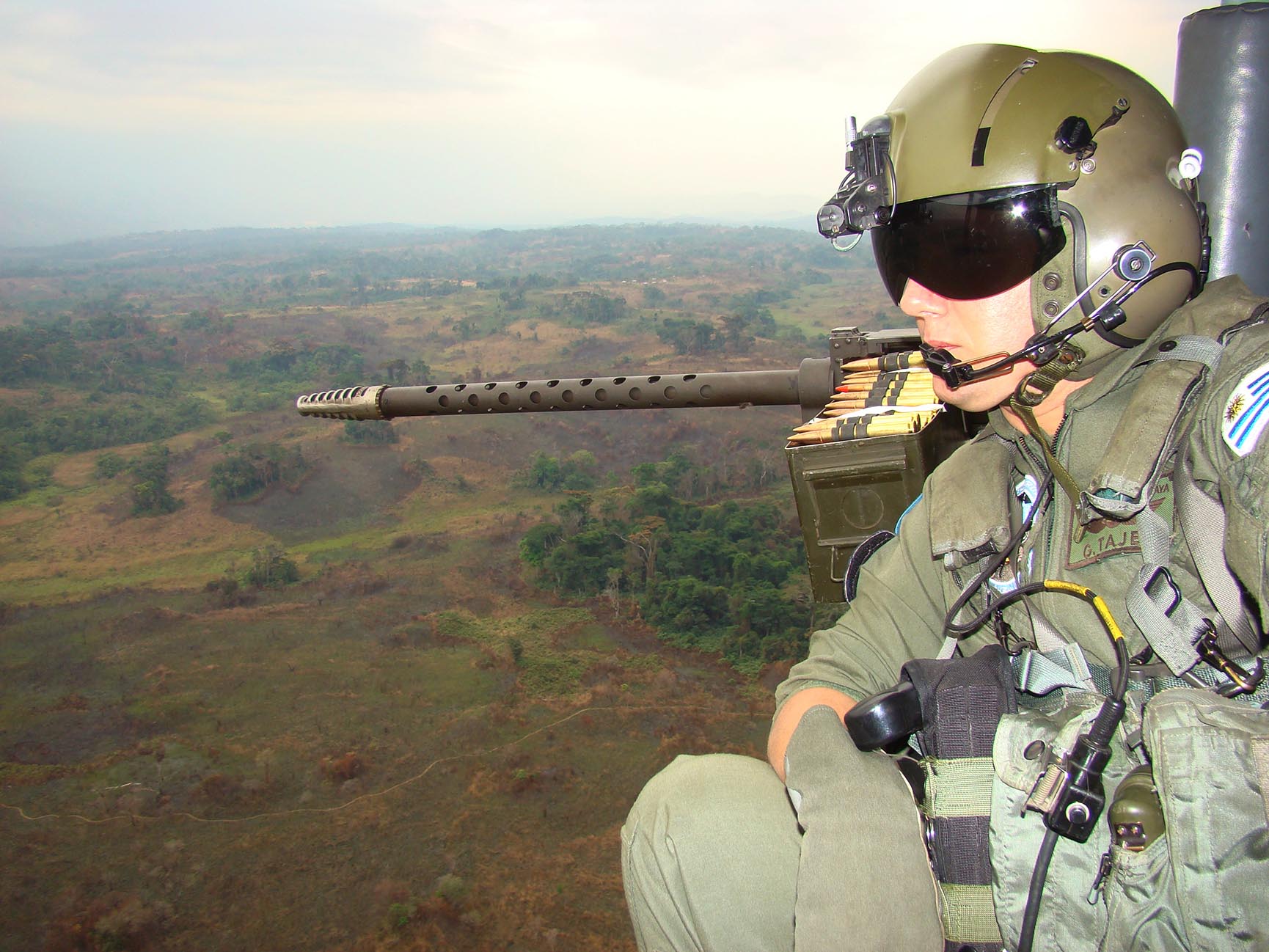 Lieutenant Colonel Tajes observes the countryside from the the open door of his helicopter in flight