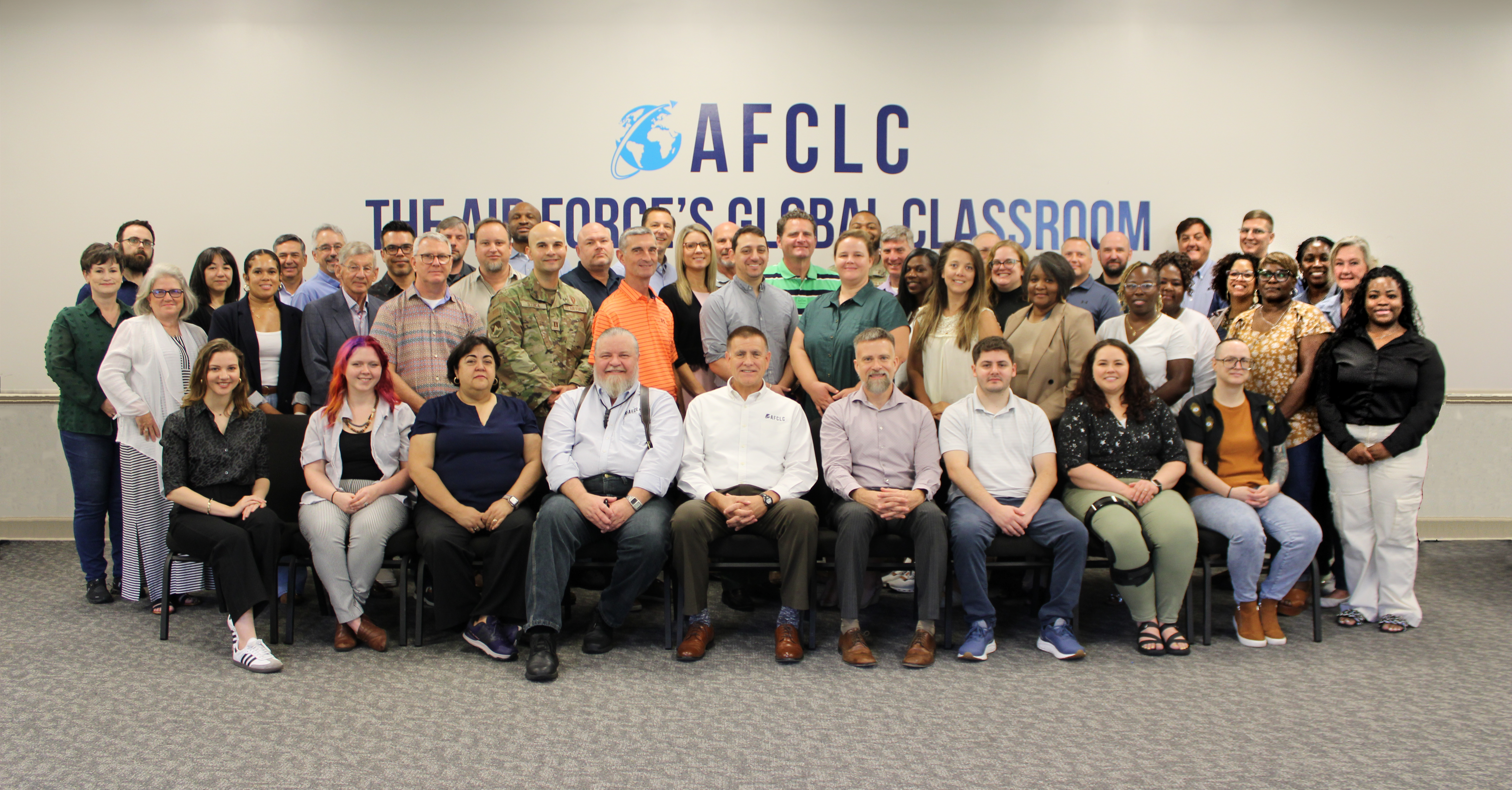 A large group of people standing around the AFCLC outdoor sign