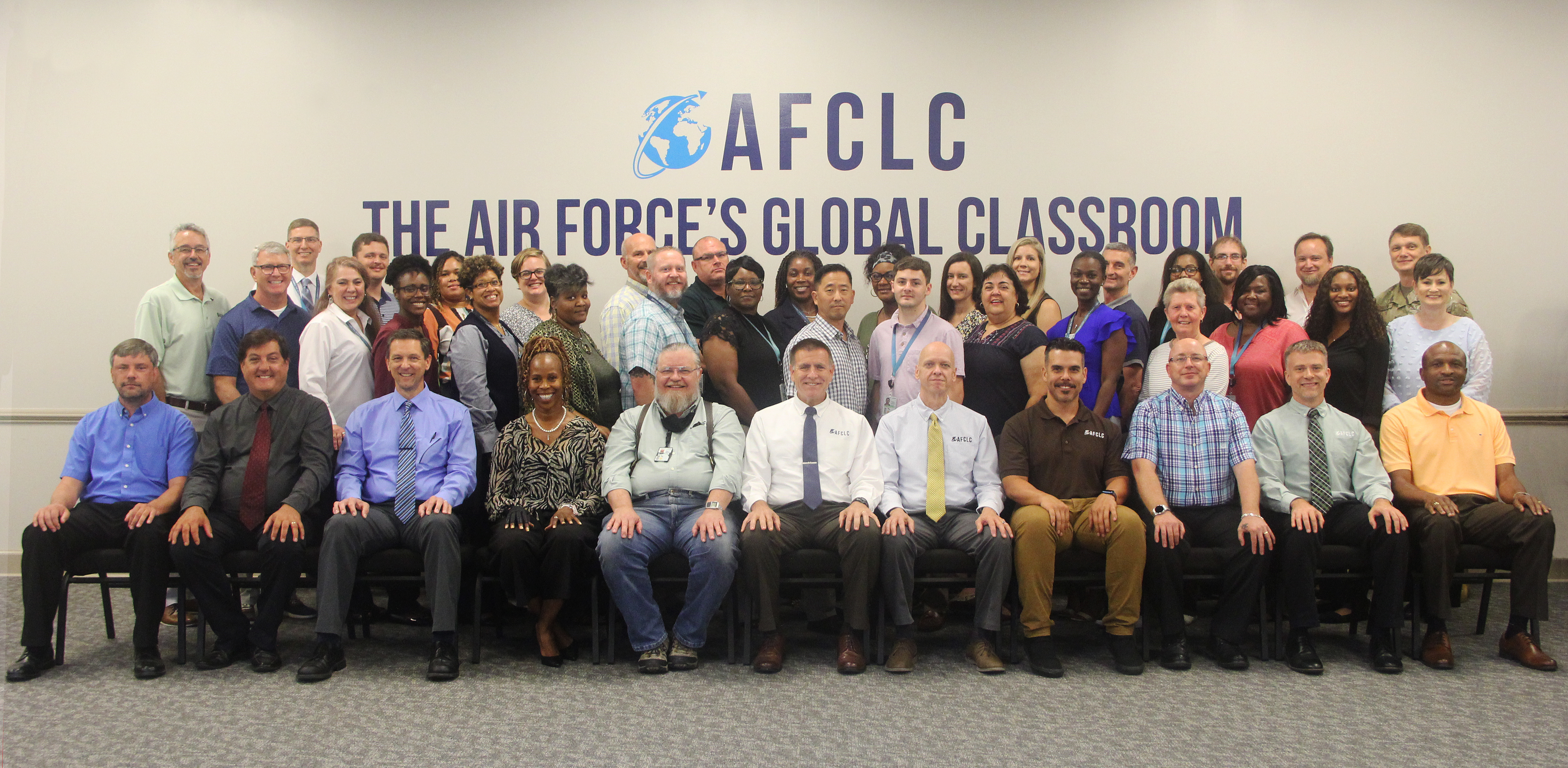 A large group of people standing around the AFCLC outdoor sign